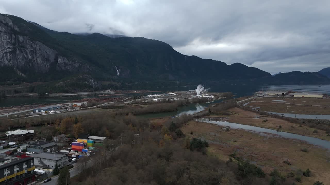 Squamish, Canada - Một Thung Lũng Công Nghiệp Trải Dài Dọc Theo Các Tuyến Đường Thủy Uốn Lượn, Được Bao Quanh Bởi Những Ngọn Núi Tối Màu và Mây Thấp - Ảnh Chụp Từ Drone Trên Không