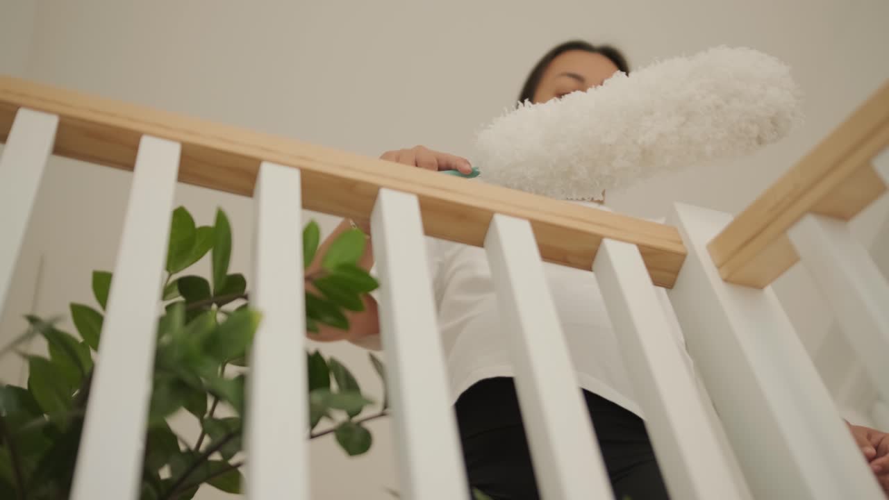 A beautiful pregnant woman tidying her home, engaged in household chores. The scene captures domestic life, maternity, and the balance of routine and preparation during pregnancy