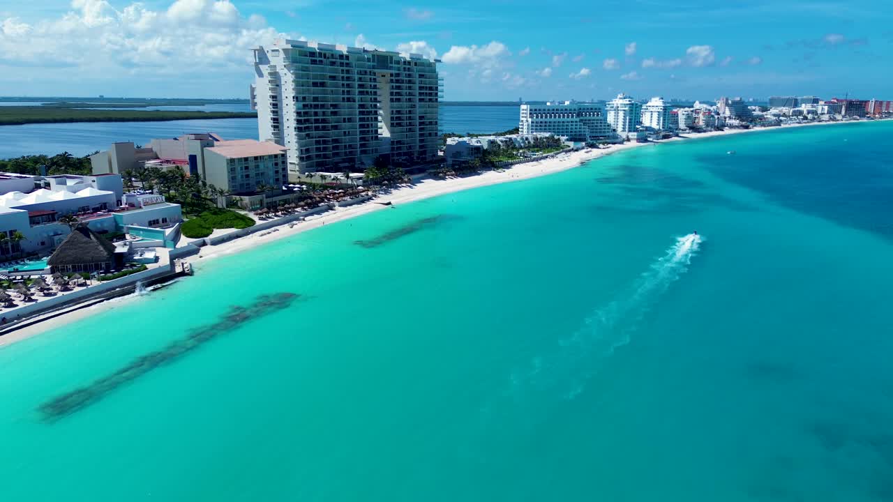 Paesaggio aereo con drone di moto d'acqua che naviga lungo un banco di sabbia sulla spiaggia sabbiosa di Cancun con resort alberghieri, vacanze, Messico, America Centrale, viaggi e turismo