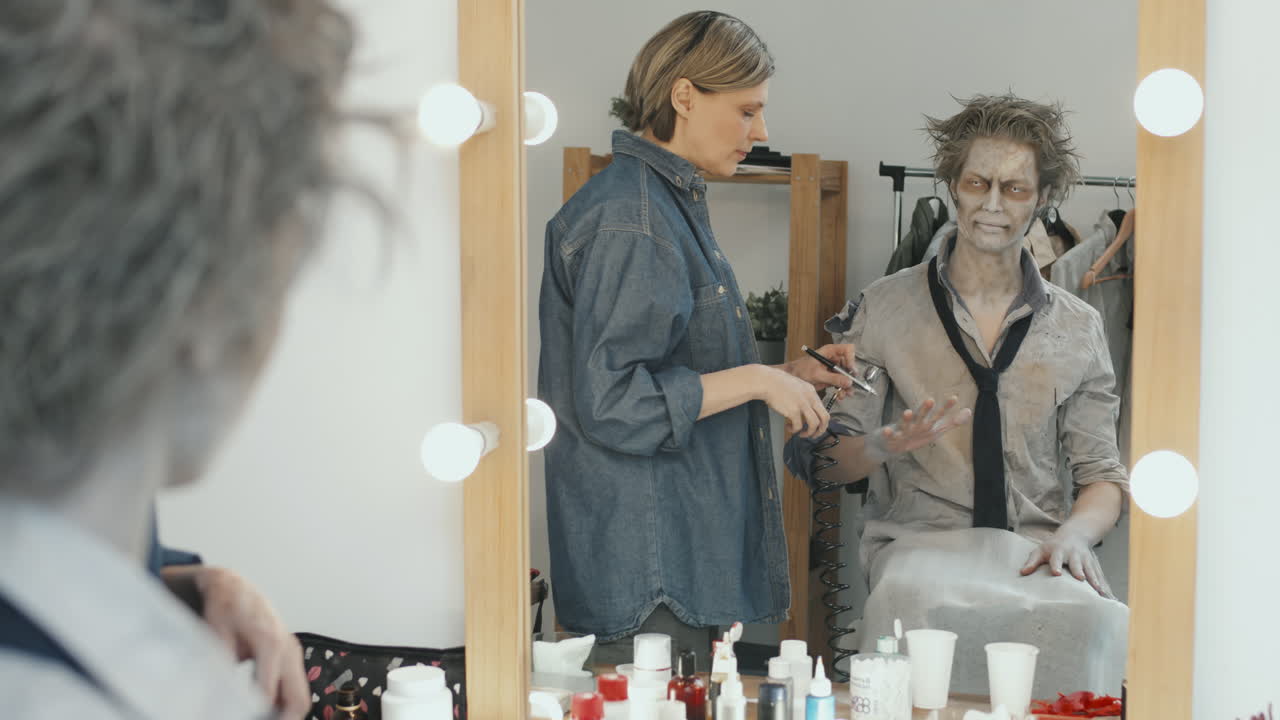 SFX-kunstner påfører kropsmaling på mand med zombie-makeup