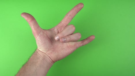 footage of male hand showing rock gesture over green background