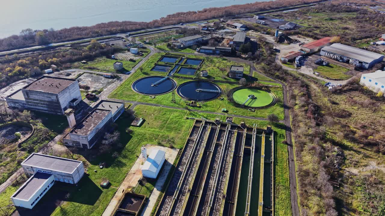 Water treatment facility with circular tanks and green fields in view
