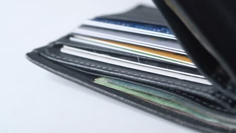 close-up of a black leather wallet with cards and cash