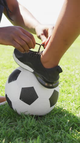 video de la sección media de un padre afroamericano atando un zapato a su hijo