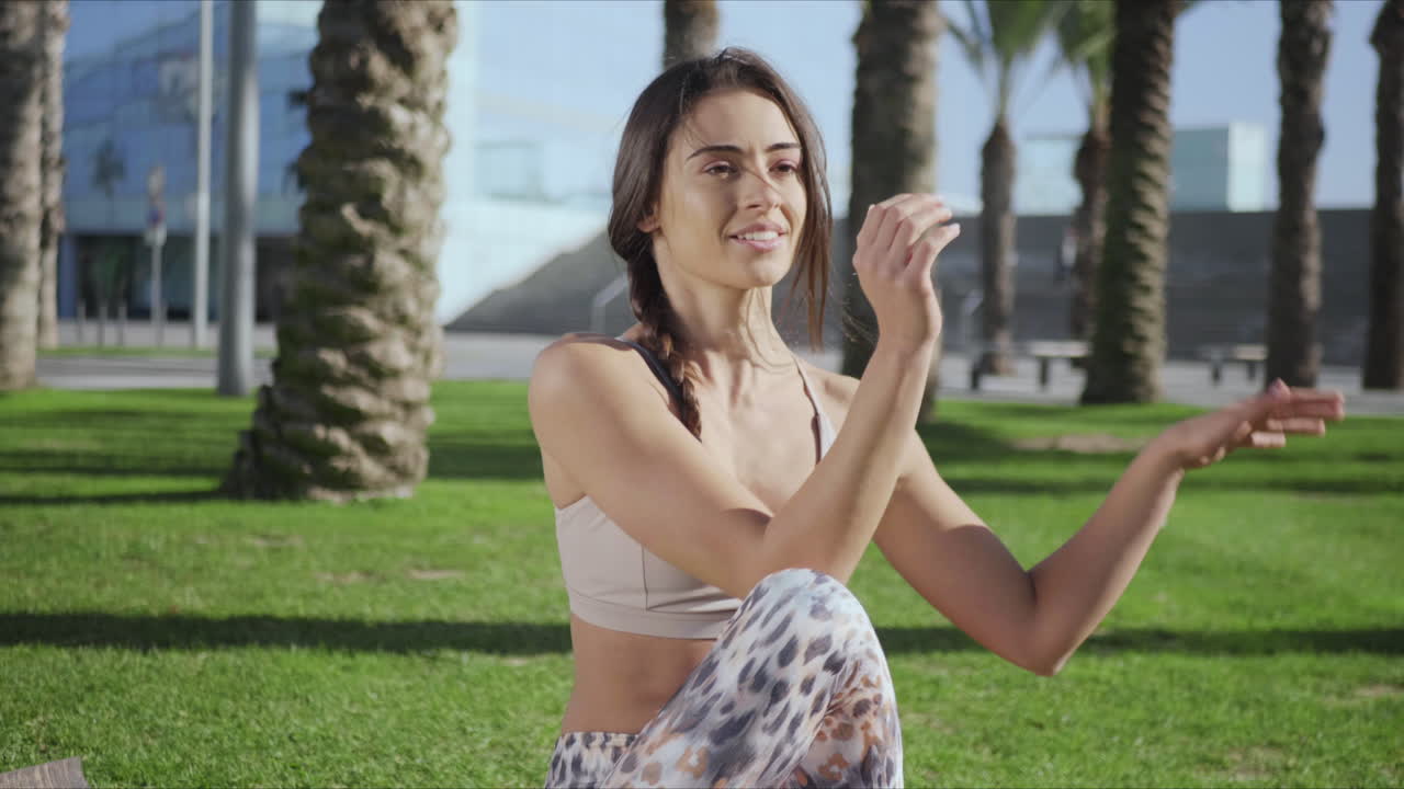 mujer haciendo una postura de torsión espinal sentada en el tapete. chica realizando yoga en el parque