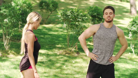Fitness-couple-warm-up-together-before-training-in-summer-park