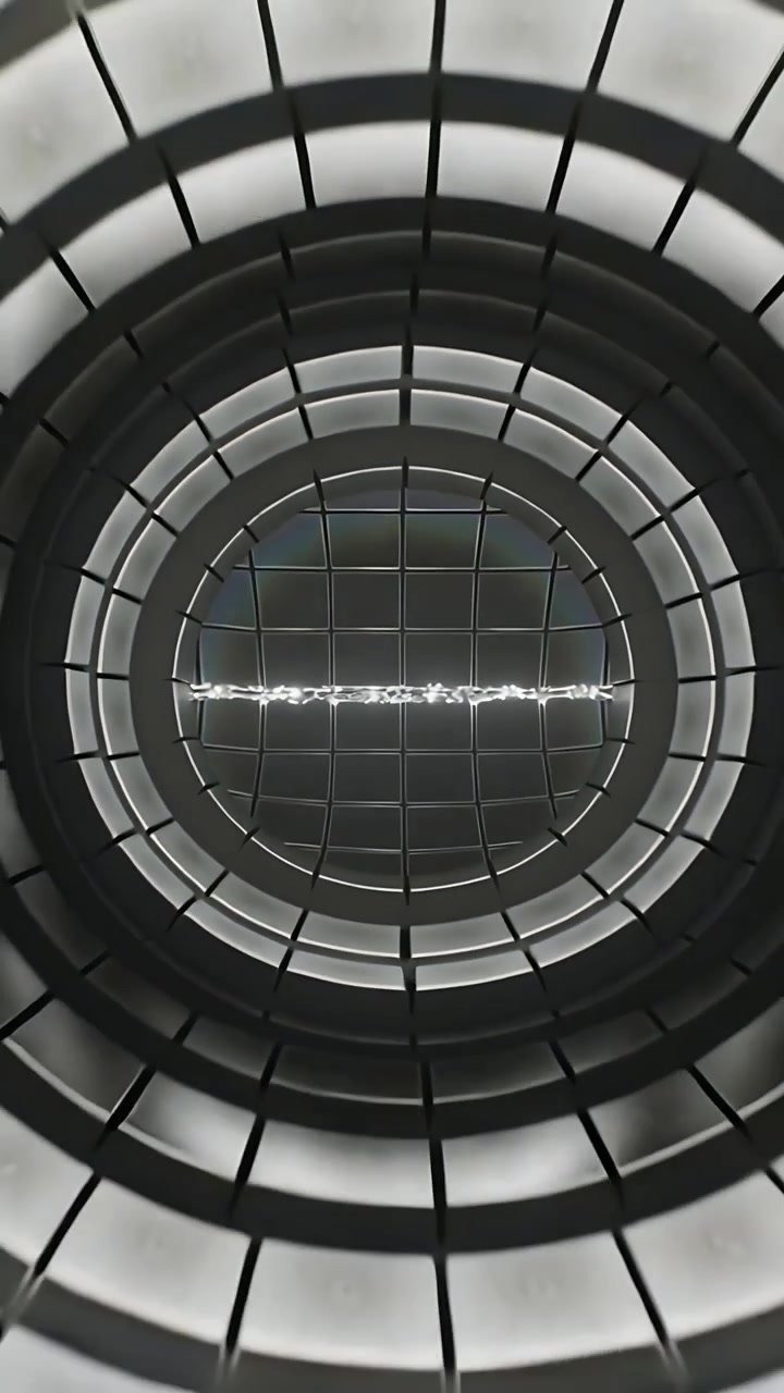 Video verticale: Telecamera che si allontana rivelando un pozzo ad anelli in un atrio per mostrare una griglia centrale e una linea illuminata