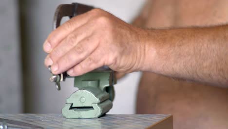 close-up, old men with saw saw for metal saws sandwiched in vise bolt