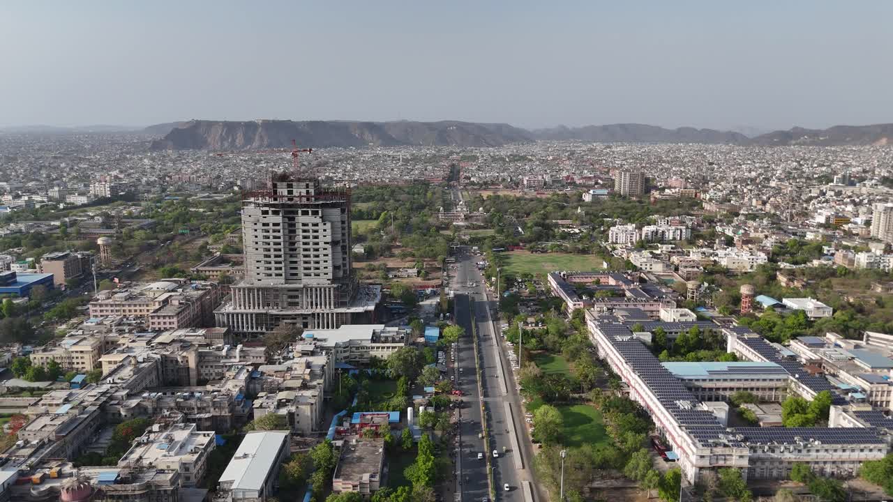 Aerial shot of a majestic underconstuction buildings with solar panels and urban buildings