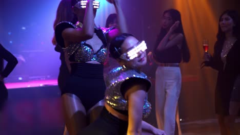 grupo de personas bailando en un club nocturno de discoteca al ritmo de la música de dj en el escenario