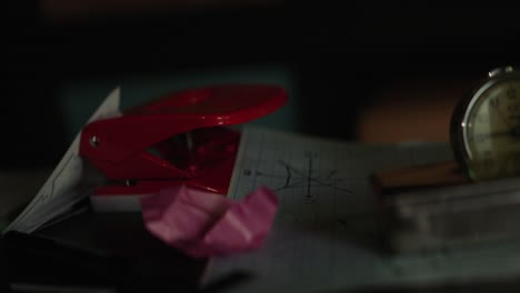 school desk with papers, clock, and puncher