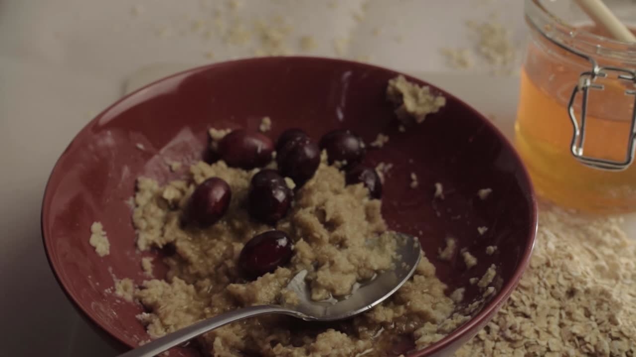 Healthy breakfast of porridge, cranberries and honey panning shot