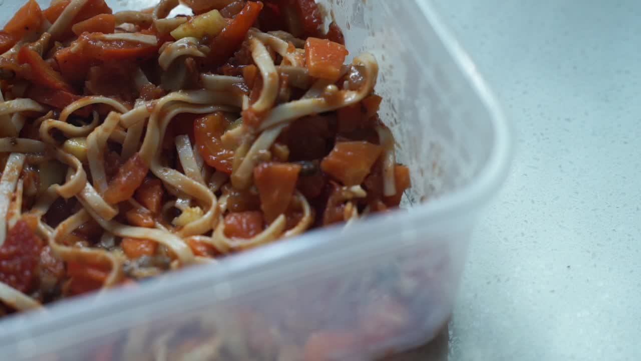 Close Up - Opening lid of plastic food box with pasta
