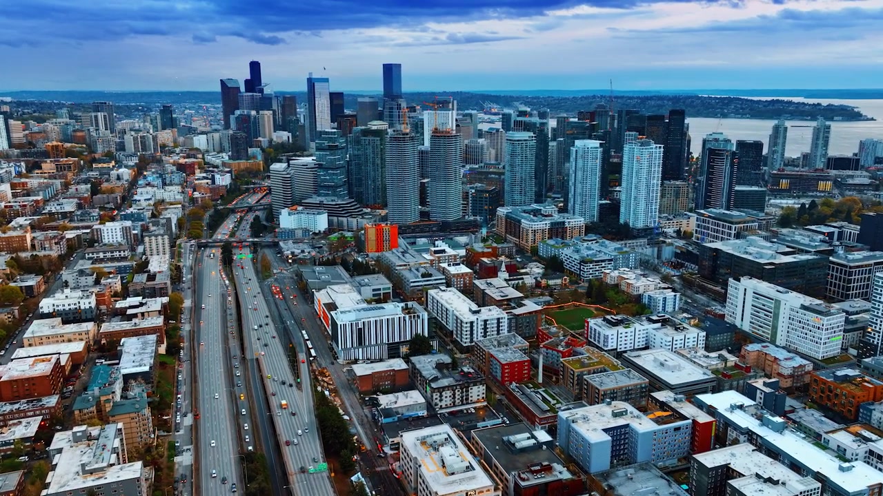 Drone lentää monikaistaisen moottoritien yläpuolella metropolin keskustassa. Seattlen, Washingtonin, Yhdysvaltojen kaupunkikuva hämärässä.