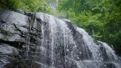 appalachian waterfall in the summer. slow motion of water rushing down waterfall.
