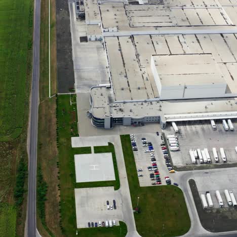 industry on green field. trucks and cars near the modern factory. roofs of a large industrial plant with car parking. aerial view