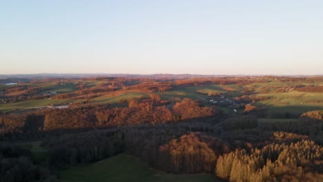 Aerial-footage-of-small-villages-and-colourful-trees-at-sunset-in-west-Germany