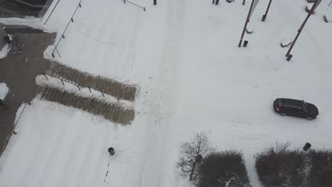 video de drones de la vista de arriba hacia abajo de un automóvil conduciendo sobre la nieve