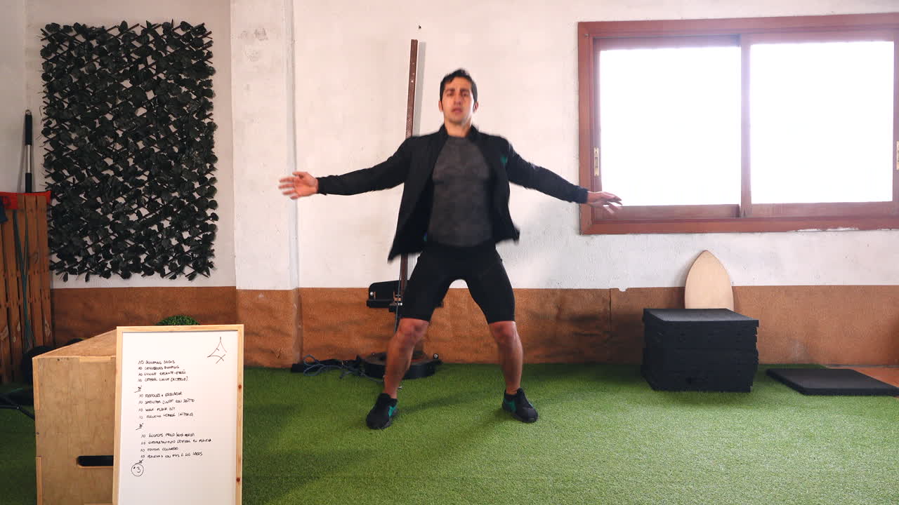 coach doing jumps looking at camera warming up during online exercise class