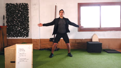 coach doing jumps looking at camera warming up during online exercise class