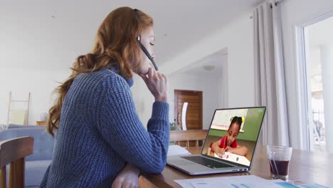 maestra caucásica usando portátil y auriculares de teléfono en videollamada con una colegiala