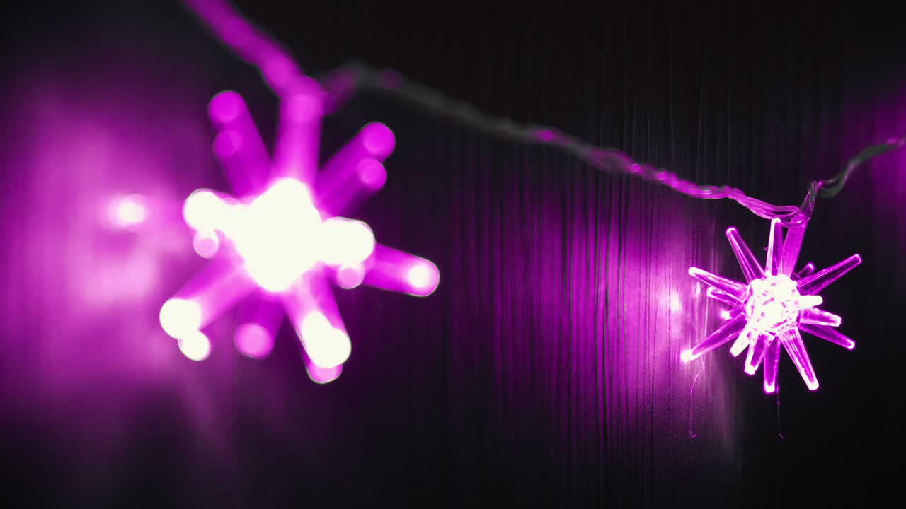 어두운 벽에 있는 분홍색 별줄의 불빛