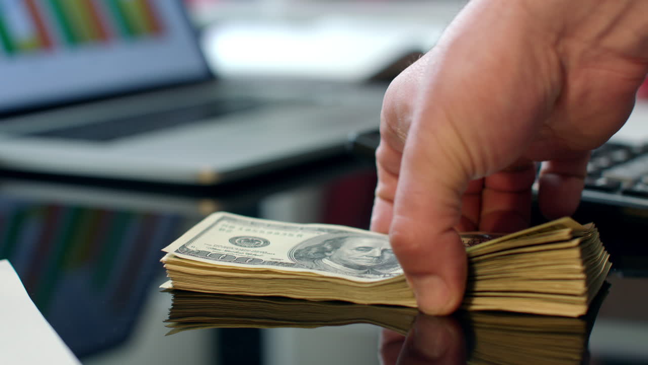 transferencia de montones de billetes de dólares de una mano a otra. transferencia instantánea de dinero