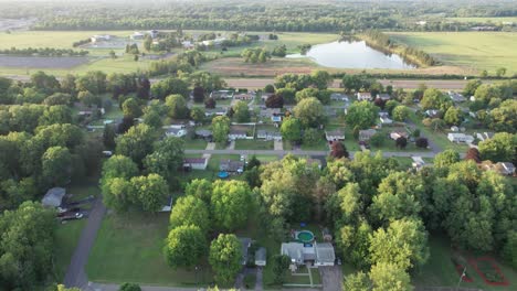 Drone-Captura-Las-Imágenes-Aéreas-De-La-Pequeña-Ciudad-Cubierta-De-árboles-Y-El-Intrincado-Patrón-De-Carretera-Desde-Gran-Altura