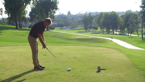 male golfer hitting tee shot on golf course in slow motion