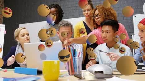 Animation-of-emoji-icons-flying-over-a-group-of-colleagues-working-in-the-office