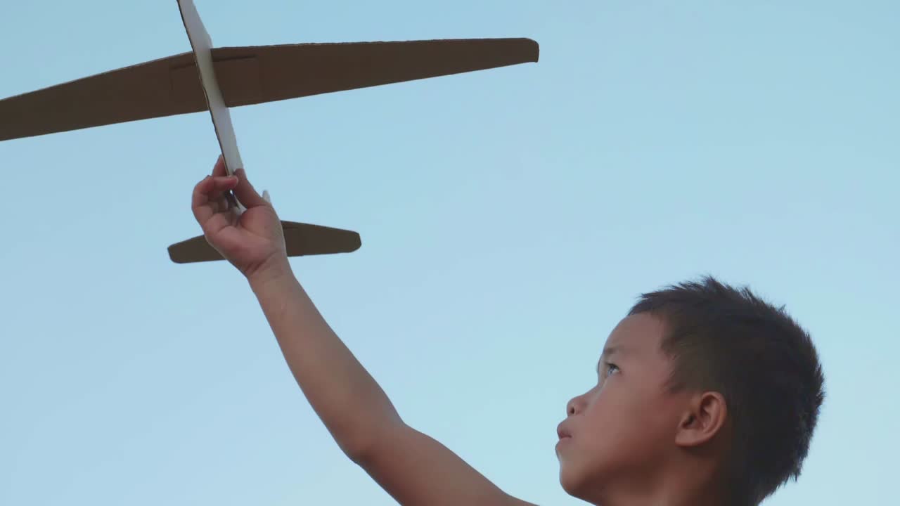 Boy playing with a cardboard airplane