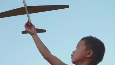boy playing with a cardboard airplane