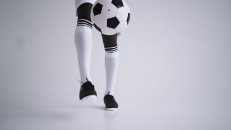 slow motion: one african man soccer player white jersey juggling in silhouette on white background. one black brazilian soccer football player man silhouette