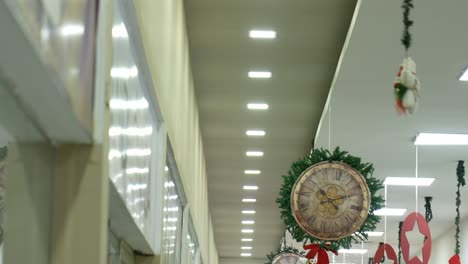 still shot of the ceiling of a shopping center with decorations hanging from it while the installed lights turn on