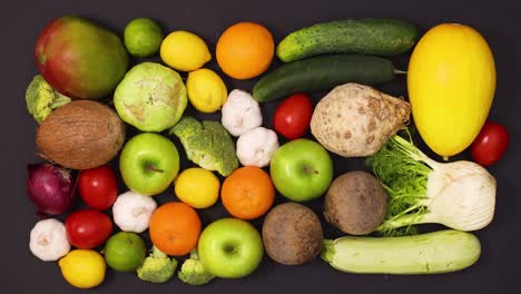 frutas y verduras frescas, maduras y saludables que se mueven en la mesa negra.