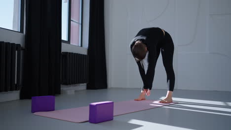 woman doing yoga stretching in a studio