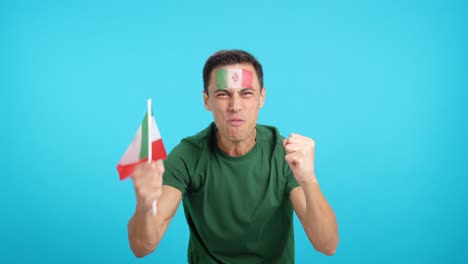 man cheering for mexico screaming and waving a national flag
