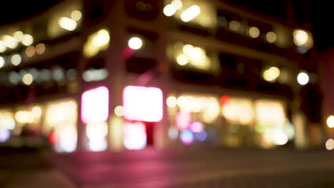 Lisbon-street-at-night-with-cars-and-people-passing-by-in-out-of-focus