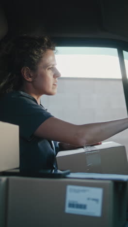 woman courier organizing packages in a delivery van