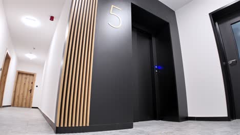 entrance to a modern black elevator with wooden decorations