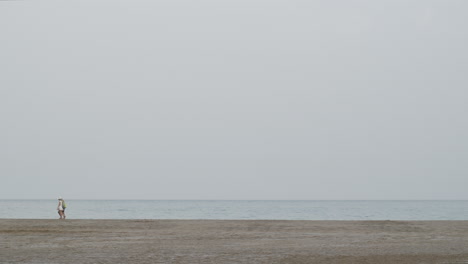 Pareja-Dando-Un-Paseo-Por-La-Playa-Vacía-Del-Océano