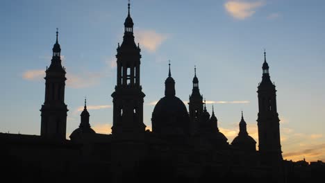 camera captures the silhouette of cathedral-basilica of our lady of the pillar during sunset in a bottom-up shot