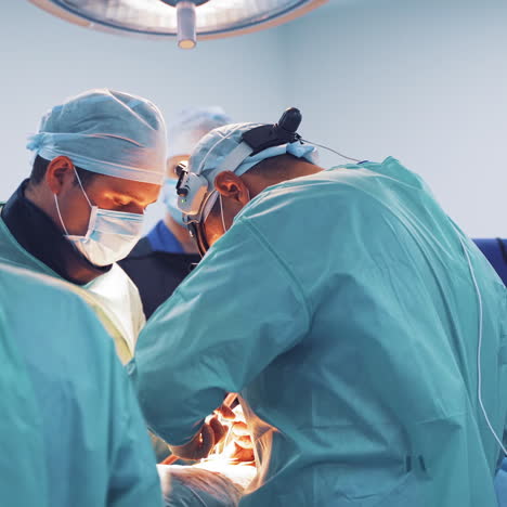 operating process of specialists. men surgeons in special uniform with sterile gloves perform an operation. neurosurgery.