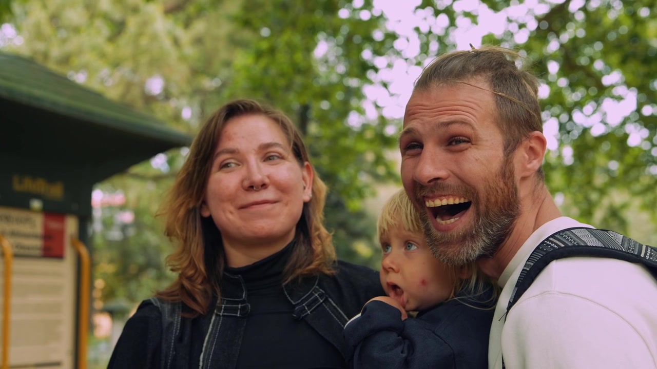 Familia feliz con un niño pequeño mirando a su alrededor en un parque