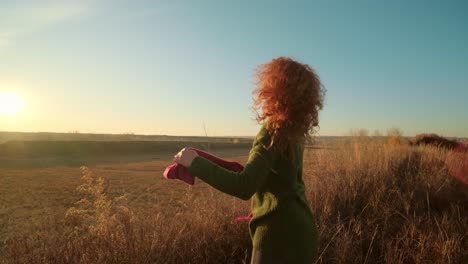 mujer disfrutando de una puesta de sol en un campo