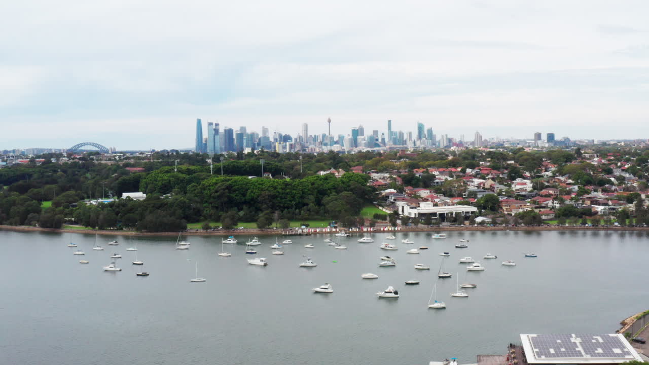 호주 시드니 시의 스카이라인과 하버 브리지 쪽으로 파라마타 강 위를 날아다니는 항공 드론 촬영