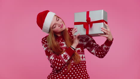 Funny-girl-wears-Christmas-holiday-sweater-received-present,-interested-in-what-inside-gift-box