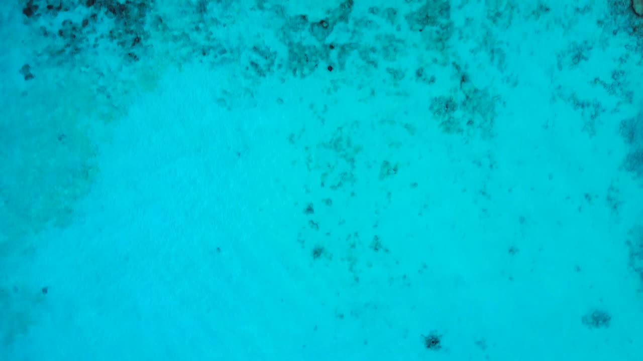 4K Birdseye View Over Turquoise Water Beach and Green Hilltop