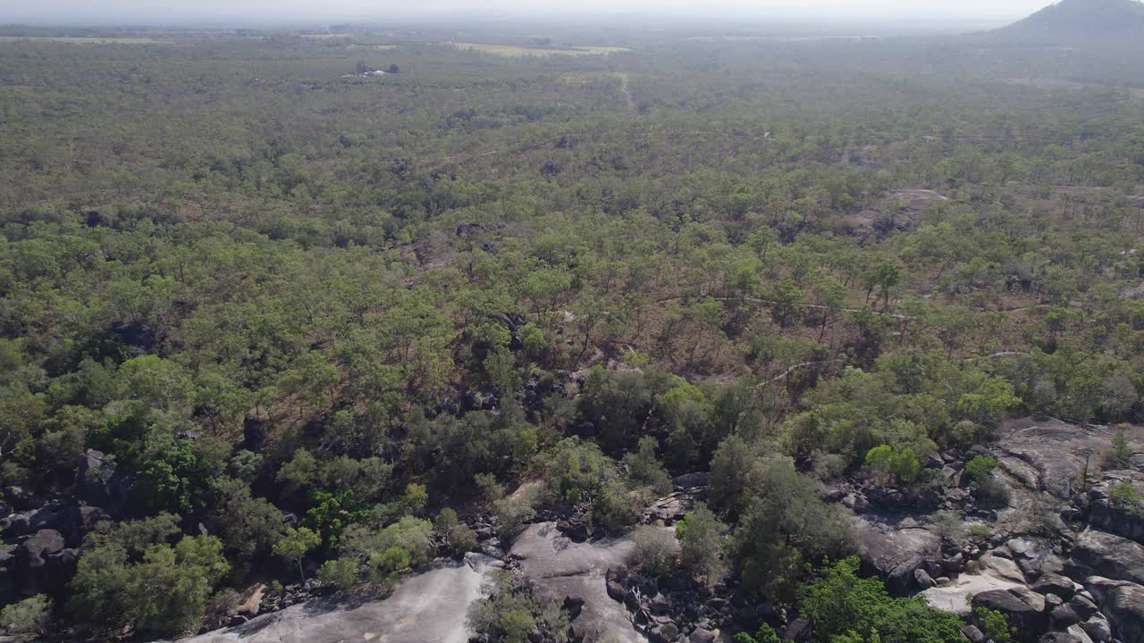 Avustralya'nın Kuzey Queensland bölgesindeki Granite Gorge Doğa Parkı'nı çevreleyen tropikal bitki örtüsü - havadan drone çekimi.