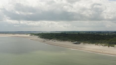 toma aérea acercándose a un pabellón de playa en una playa blanca vacía en la hermosa reserva natural de oranjezon en zelanda, los países bajos